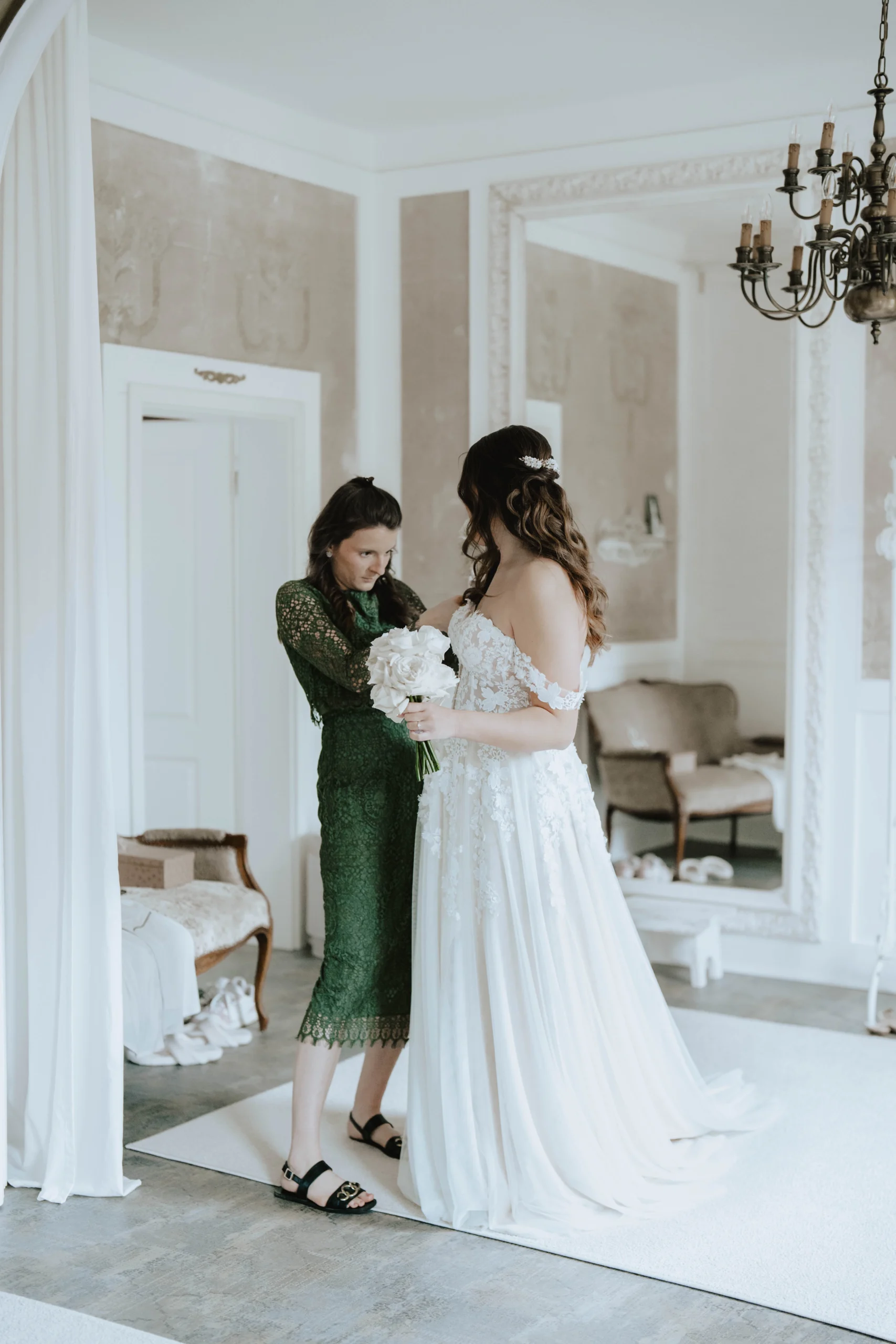 The bride carefully puts on her wedding dress, a quiet yet significant moment of preparation before the ceremony