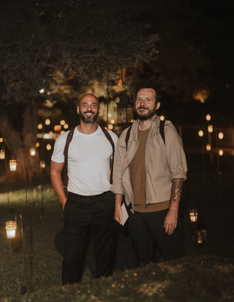 Kubi and Lukas Piatek posing outdoors at night.