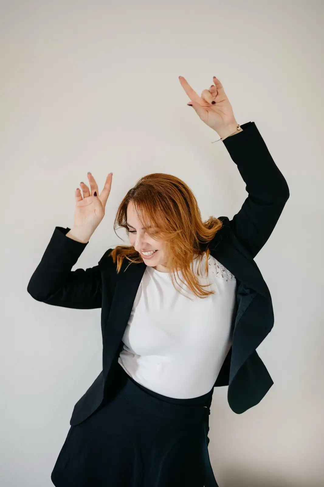 Joyful wedding planner Stefania with red hair, laughing and dancing