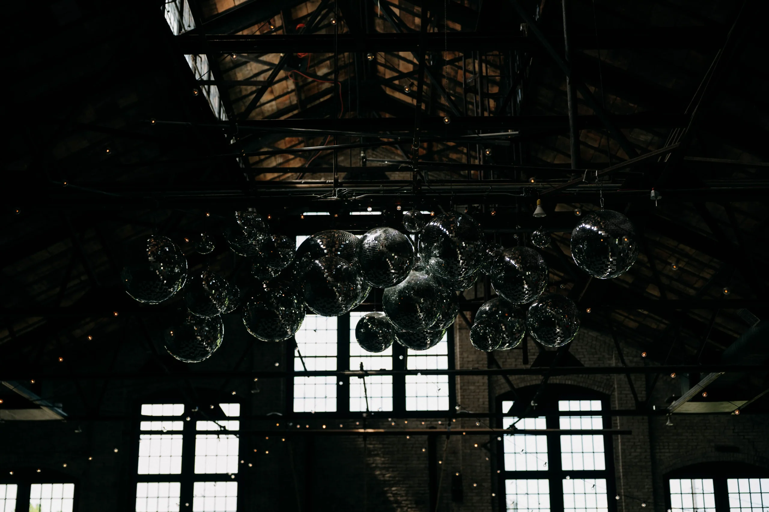 Industrial wedding venue with disco balls and dramatic ceiling lights