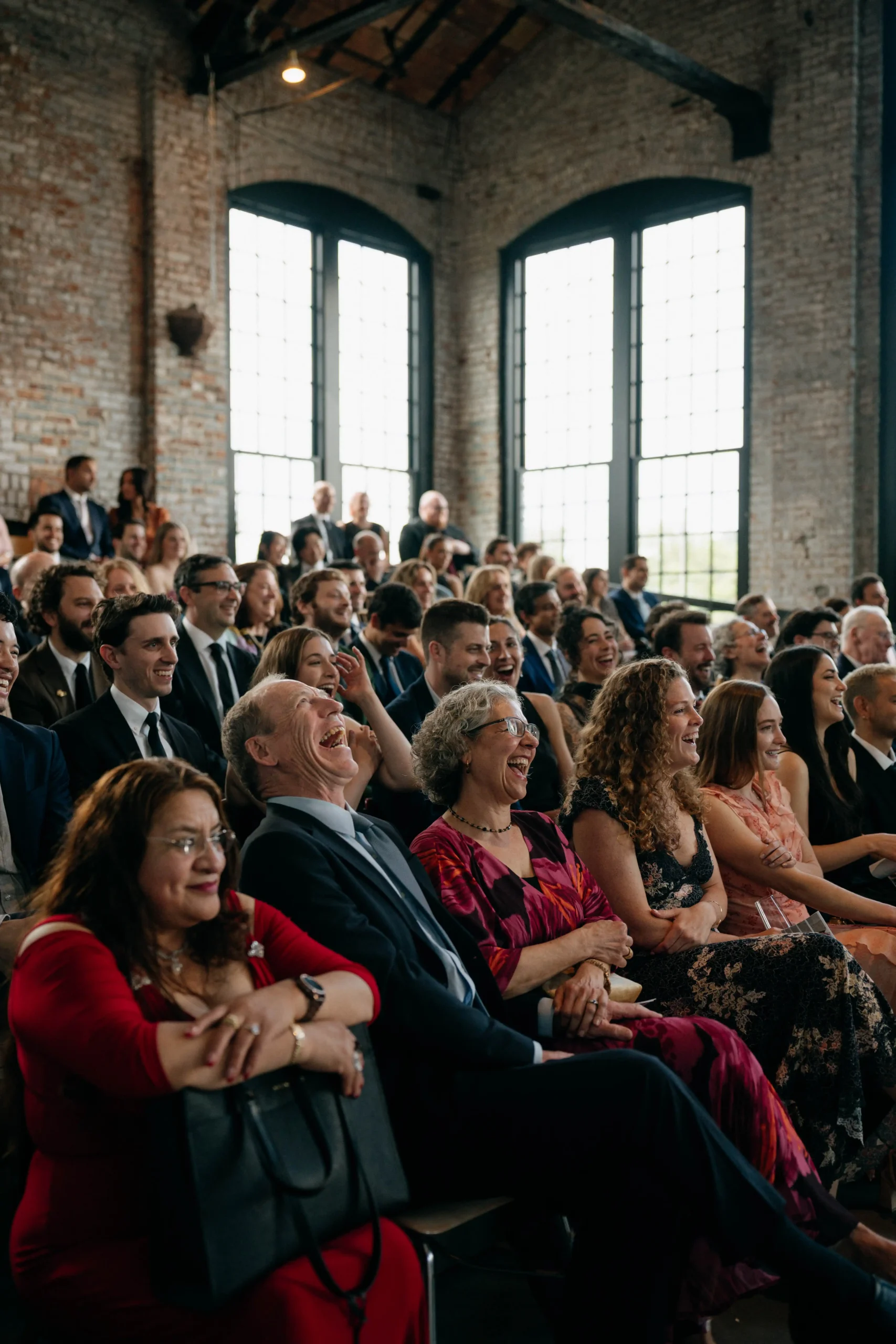 Wedding guests laughing during the ceremony.