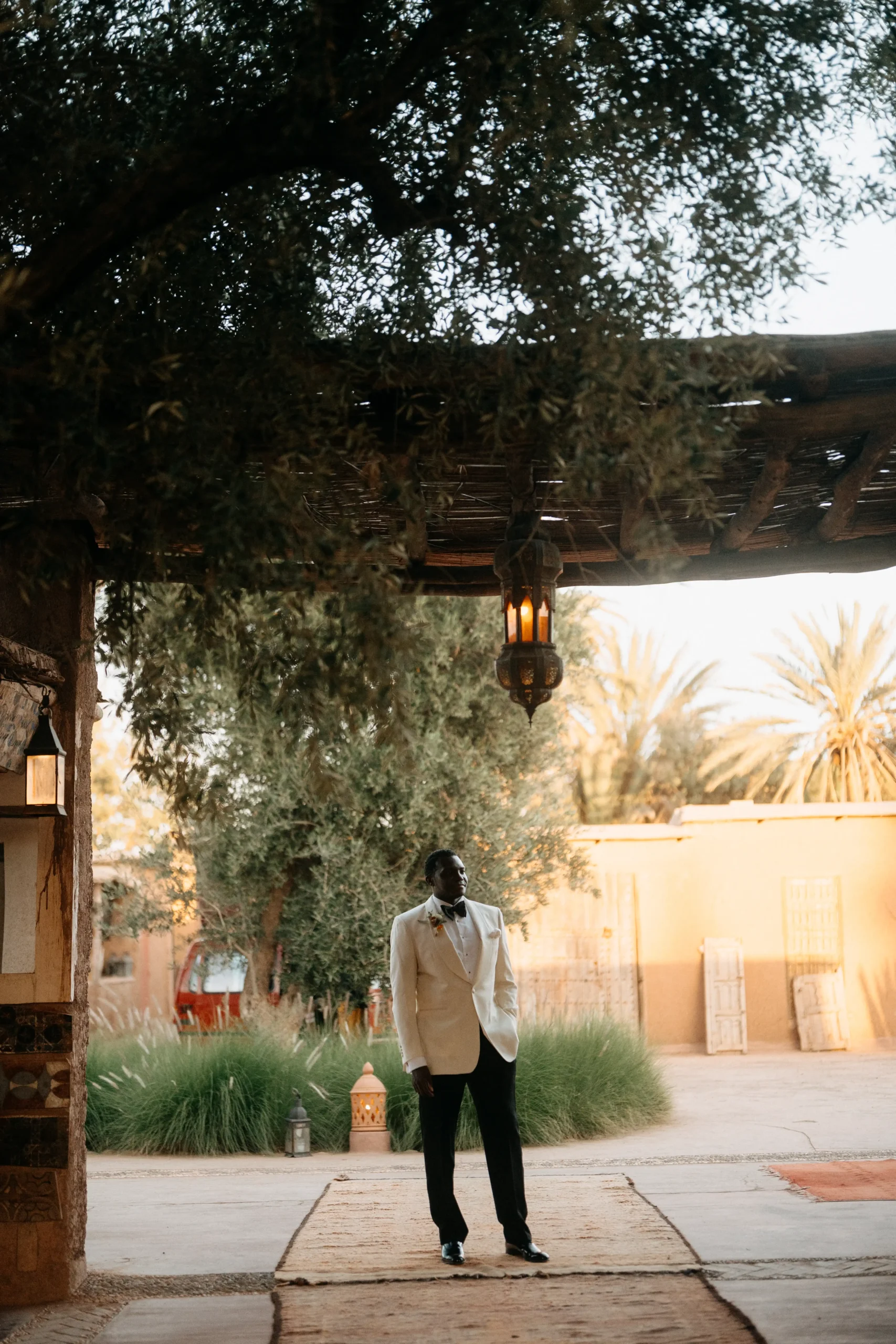 Groom standing in Moroccan courtyard before sunset at Beldi Country Club.