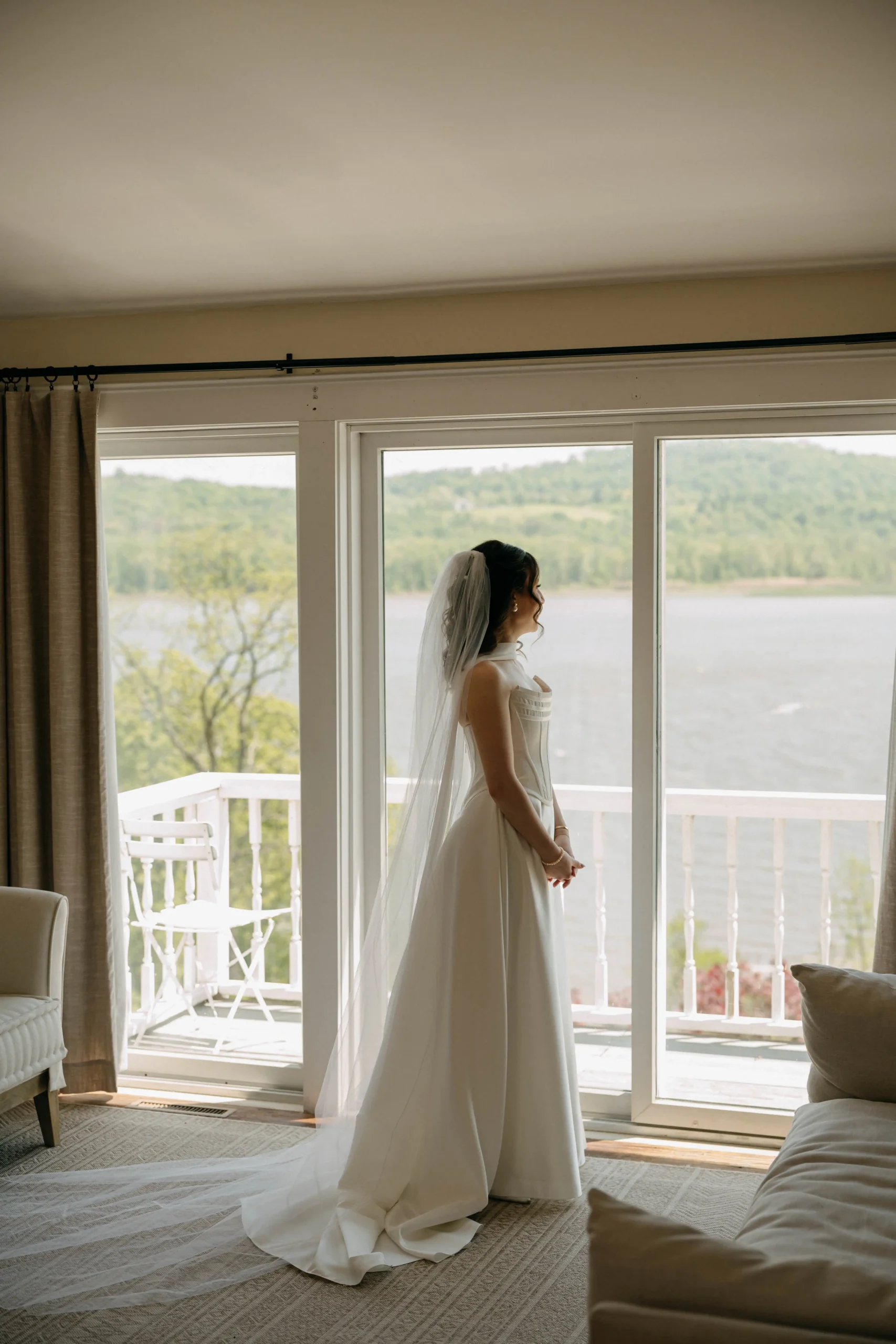 Bride looking out the window before the ceremony.