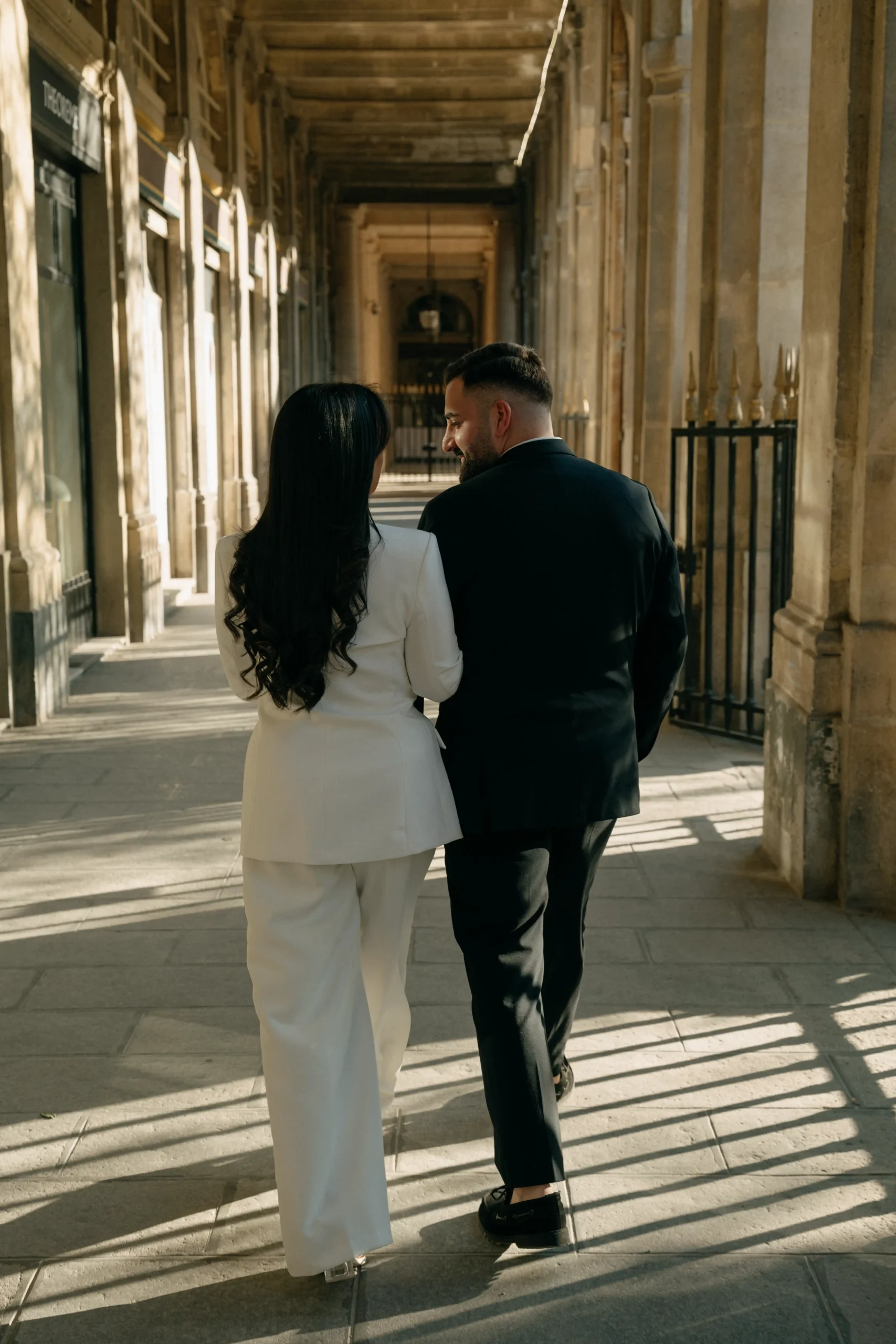 Groom walking alone near Parisian columns at Jardin des Tuileries.