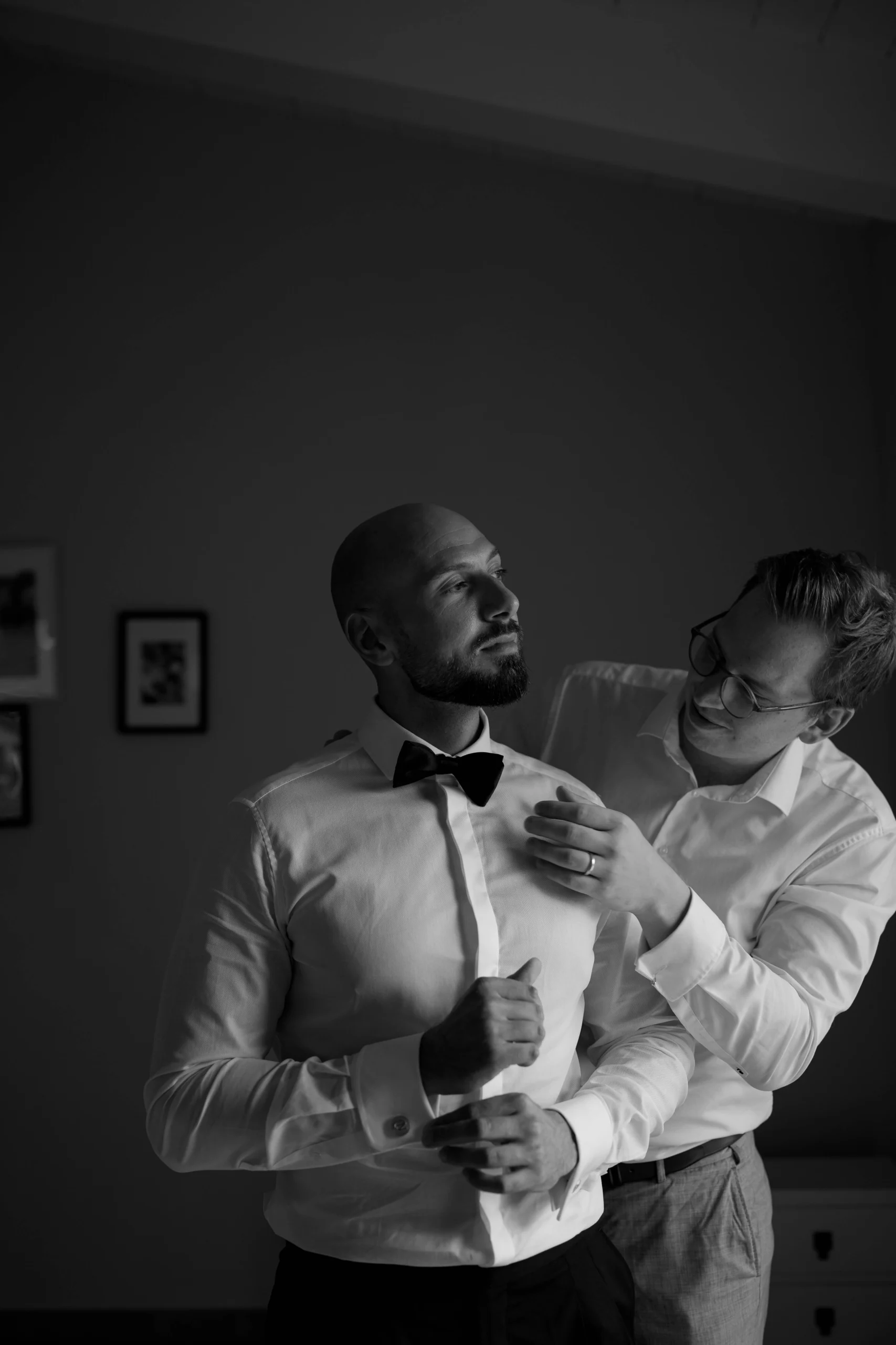 Groom getting ready with a friend – black and white candid wedding moment in Tuscany