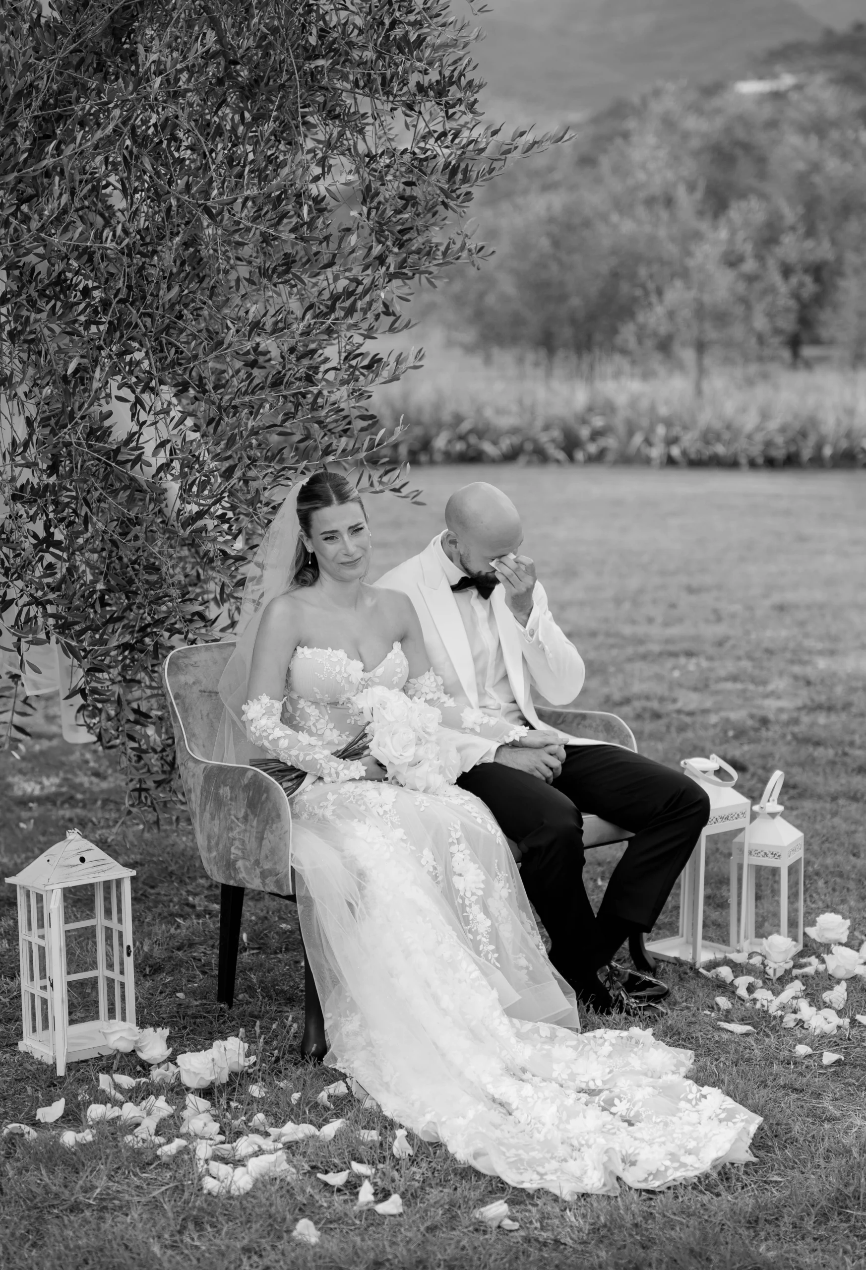 Groom wipes away tears as he sits beside the bride during their emotional wedding ceremony