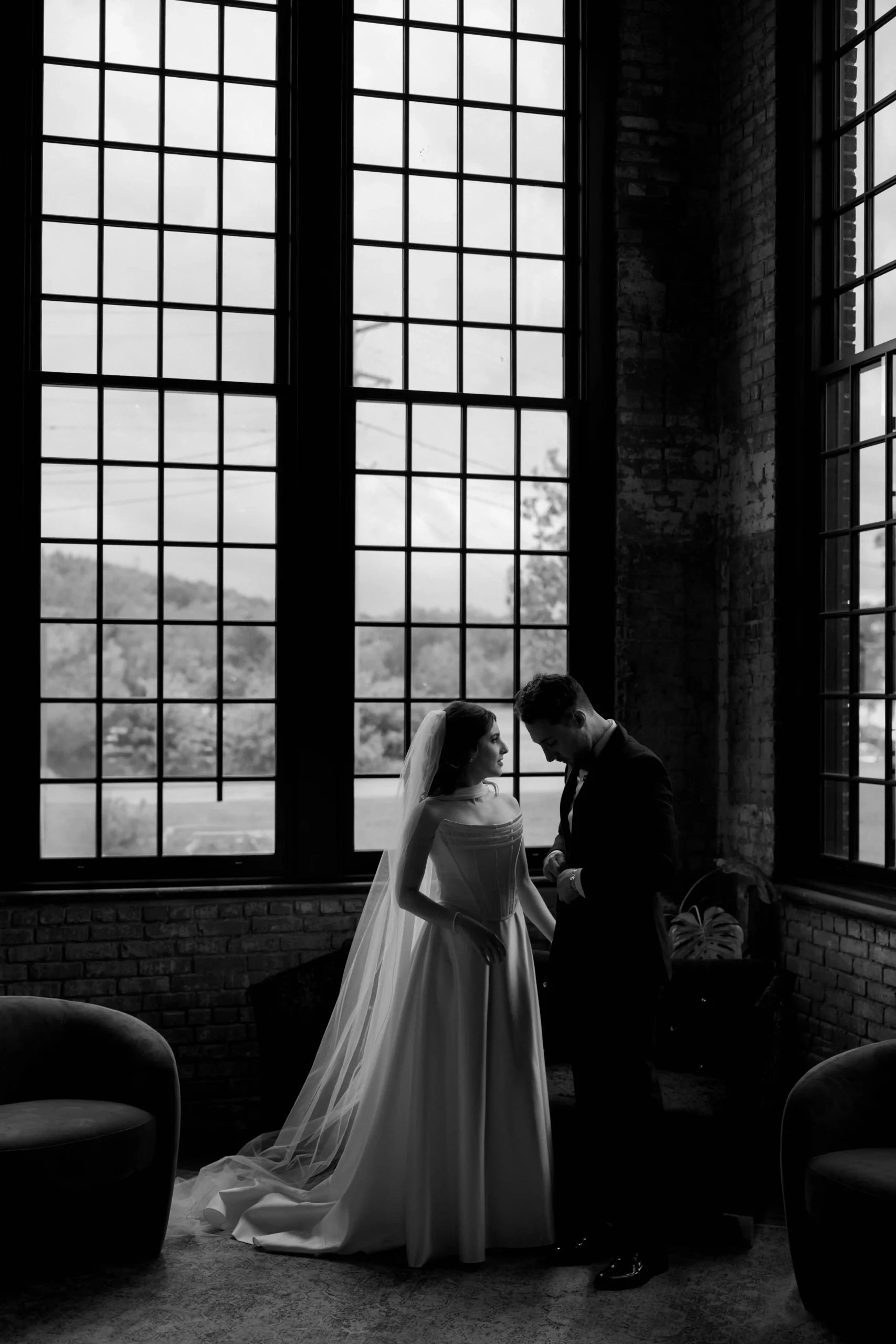 Hochzeitspaar in New York vor großen Fenstern in Schwarz-Weiß