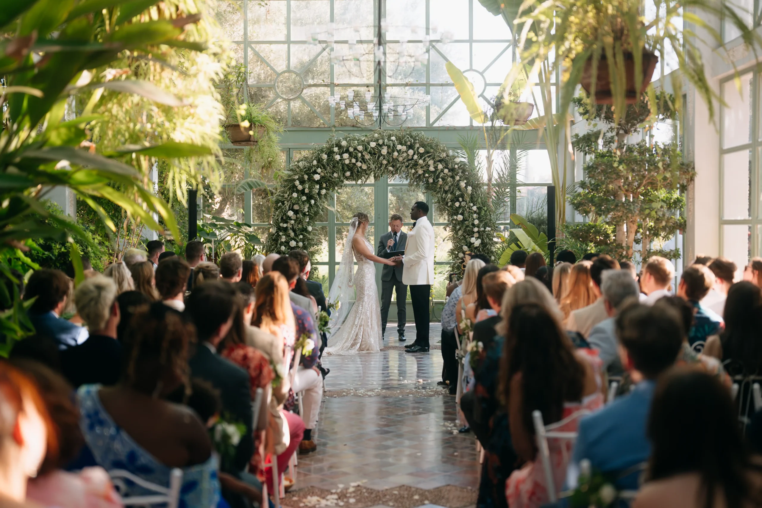 Wedding ceremony in Marrakech greenhouse with floral arch and natural light