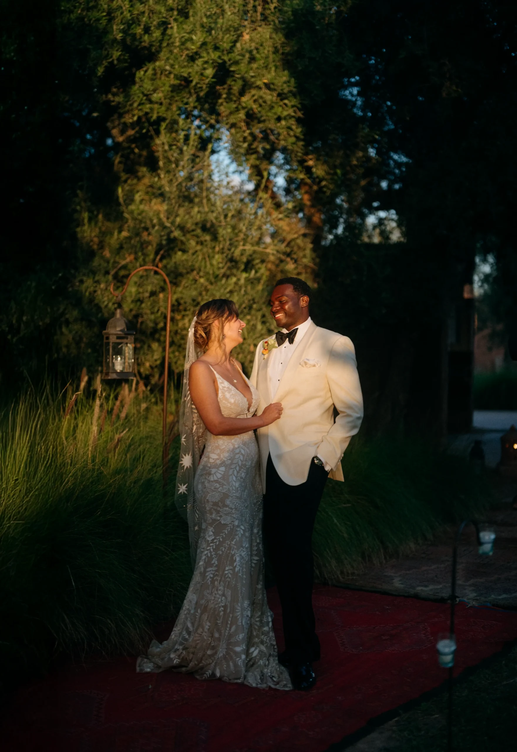 Bride hugging a guest during a Marrakech wedding, sunlight creating soft patterns on her veil