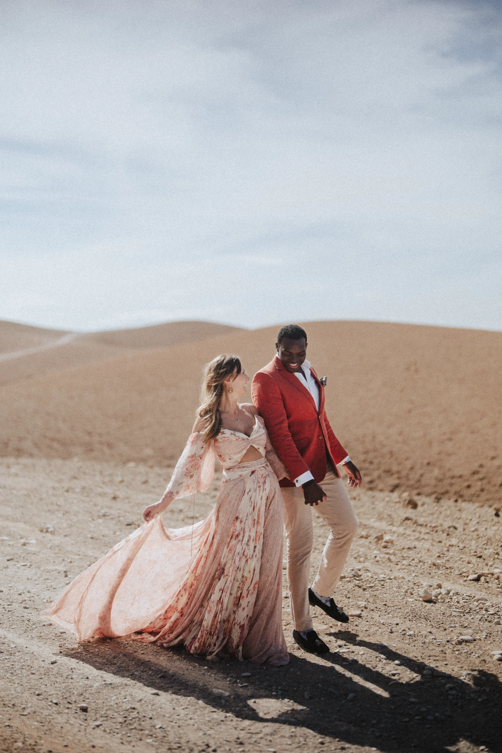 Brautpaar beim Spaziergang durch sandige Landschaft im weichen Tageslicht