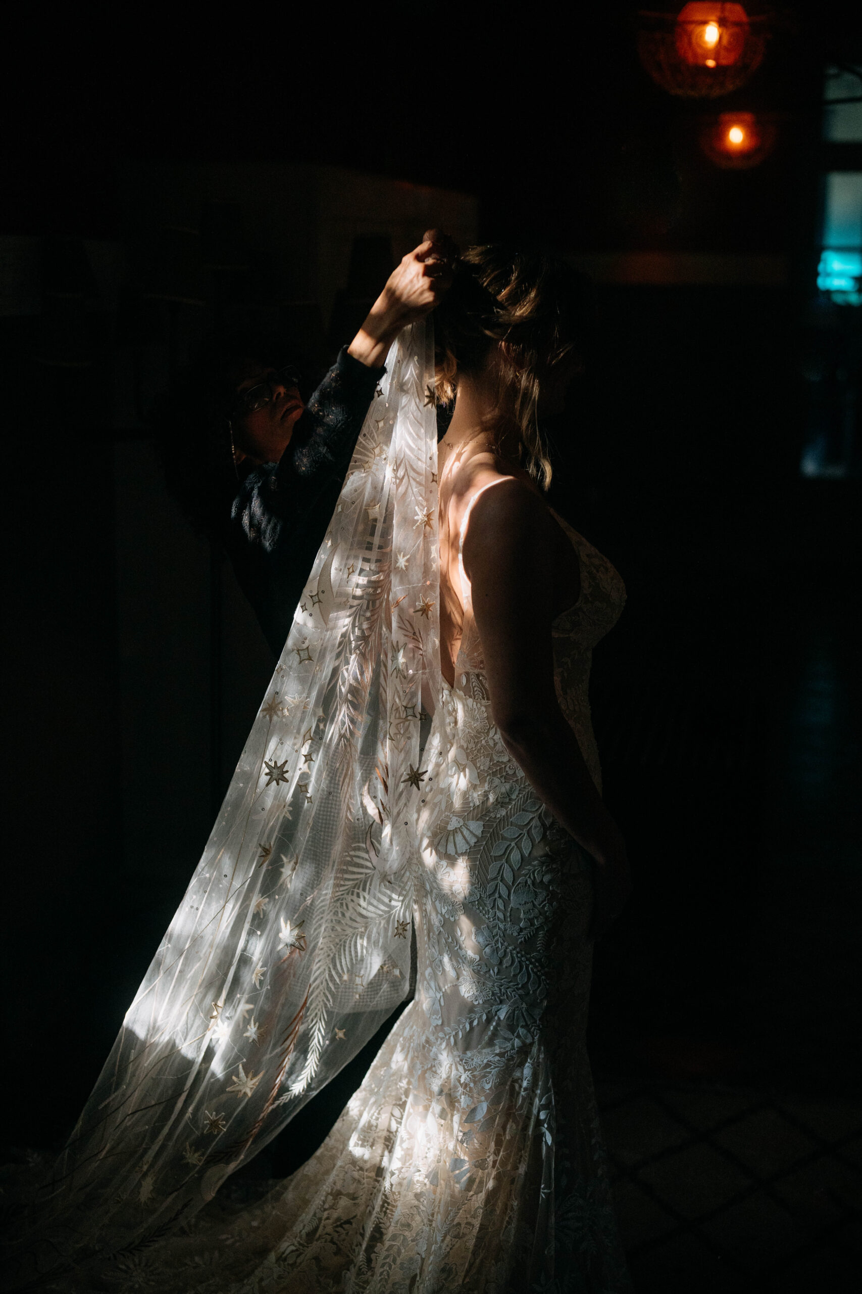Lichtstrahlen tanzen auf dem Schleier einer Braut im Dunkeln