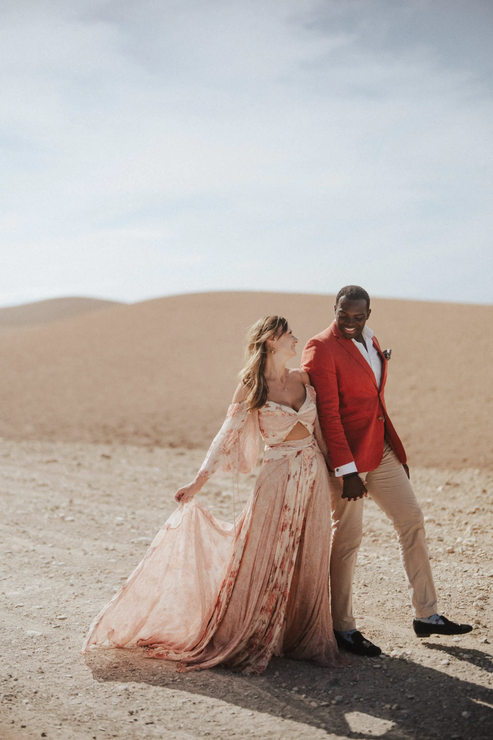 Couple walking hand in hand through the Agafay Desert near Marrakech