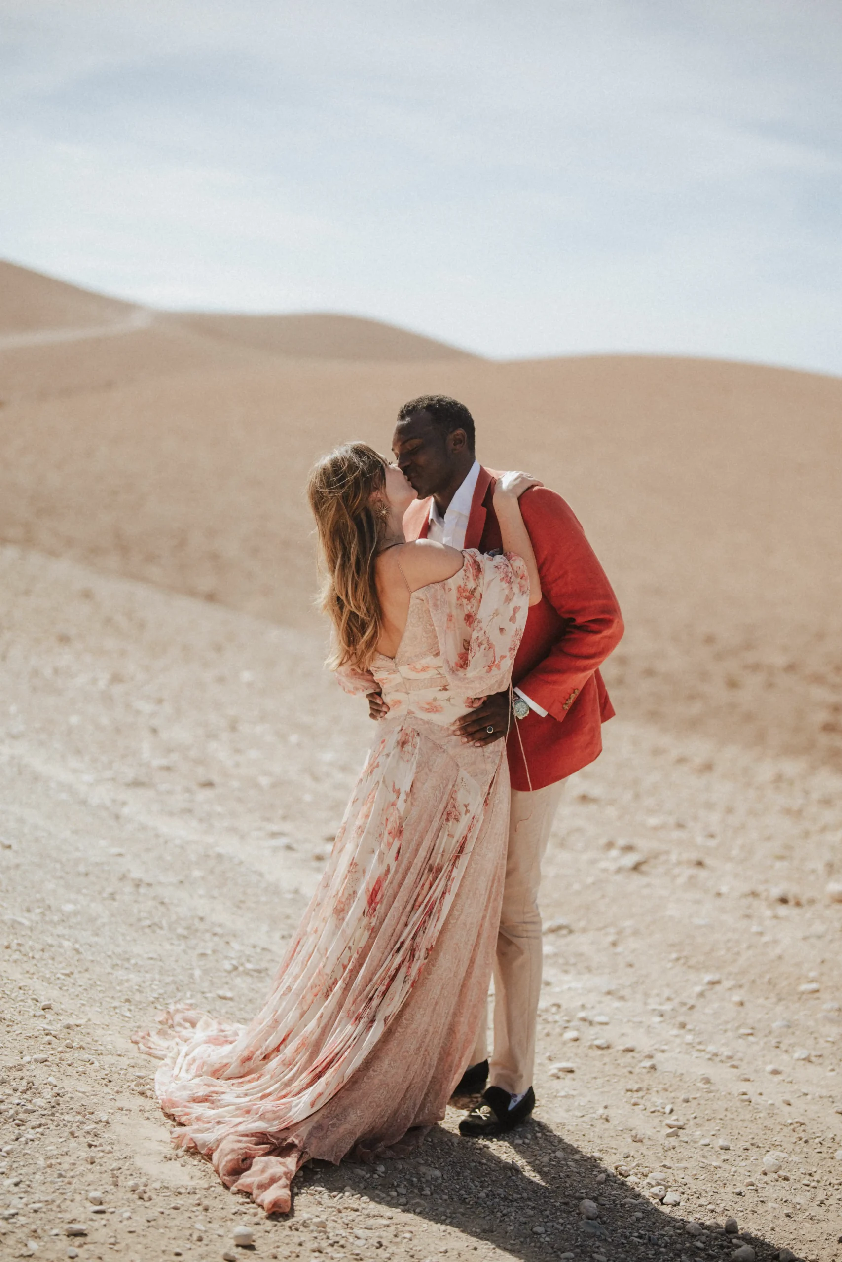 Couple kissing in Agafay Desert during cinematic Marrakech pre-wedding session