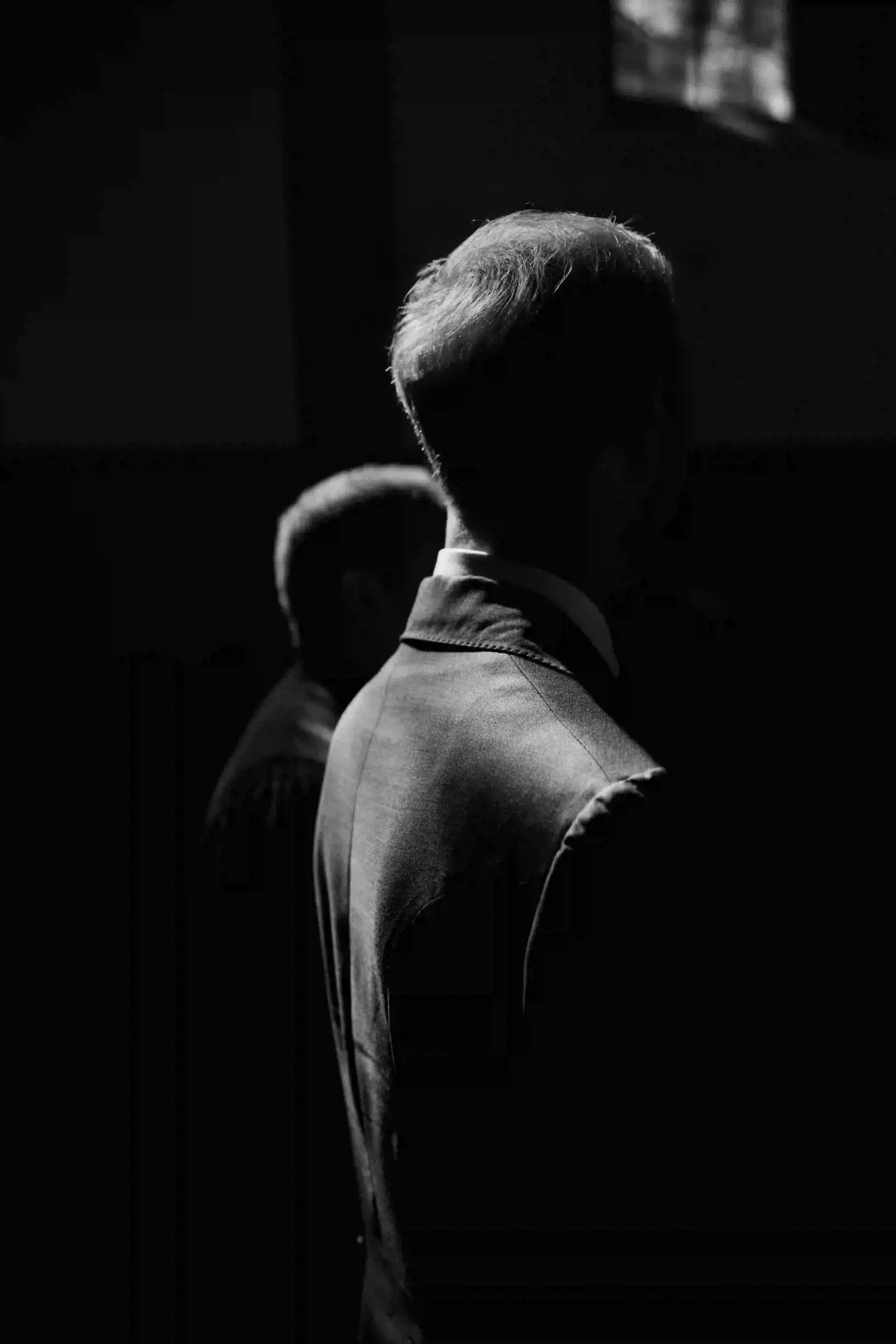 Groom in backlight, calm silhouette in a dark setting, wedding in Munich at La Villa