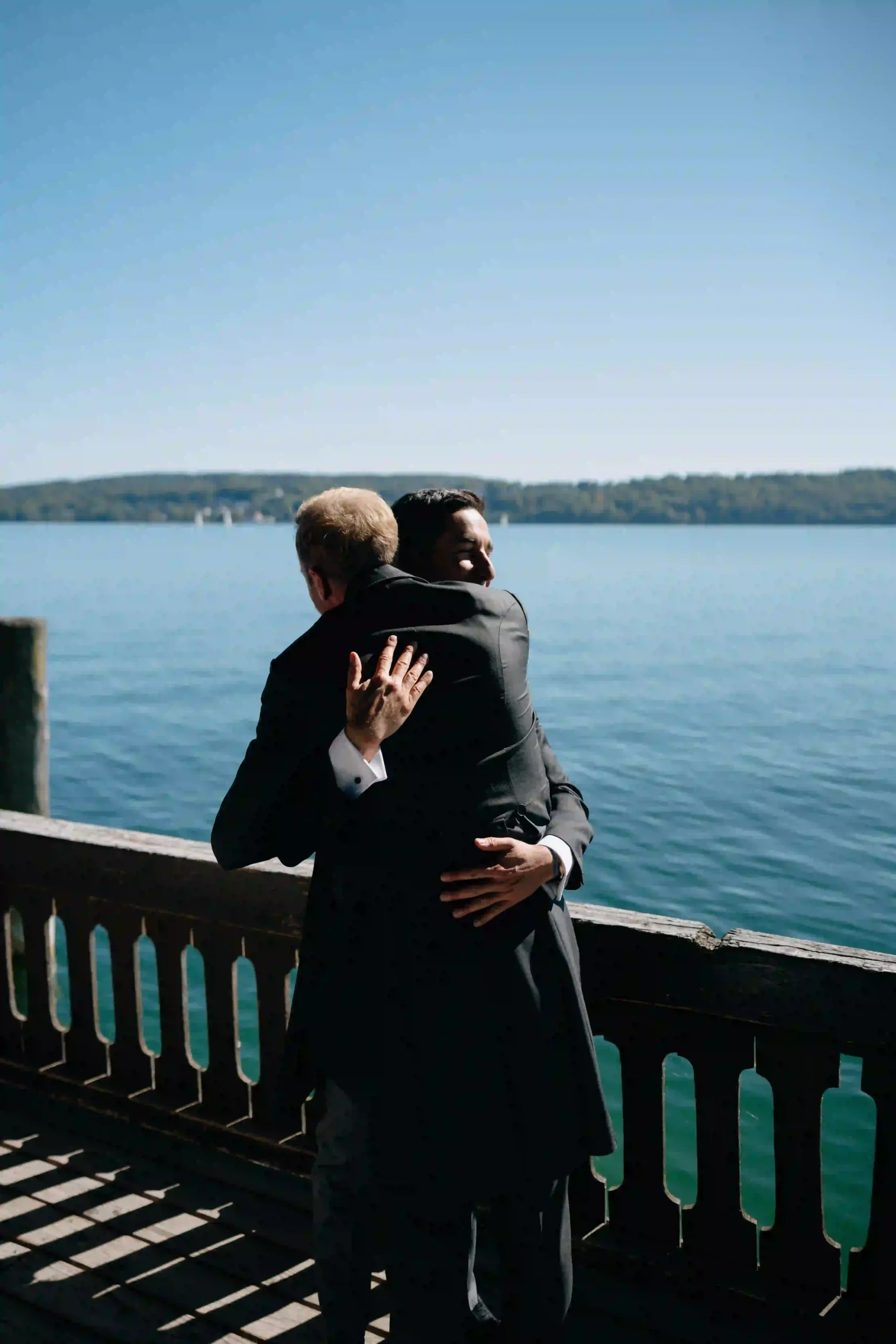 A spontaneous hug on the pier by the lake, Munich wedding at La Villa