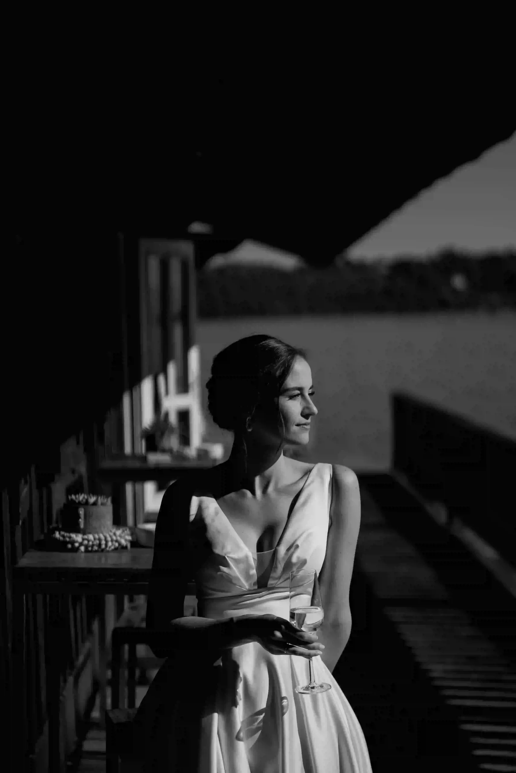 Bride on the pier in evening light holding a glass, black and white portrait, Munich at La Villa