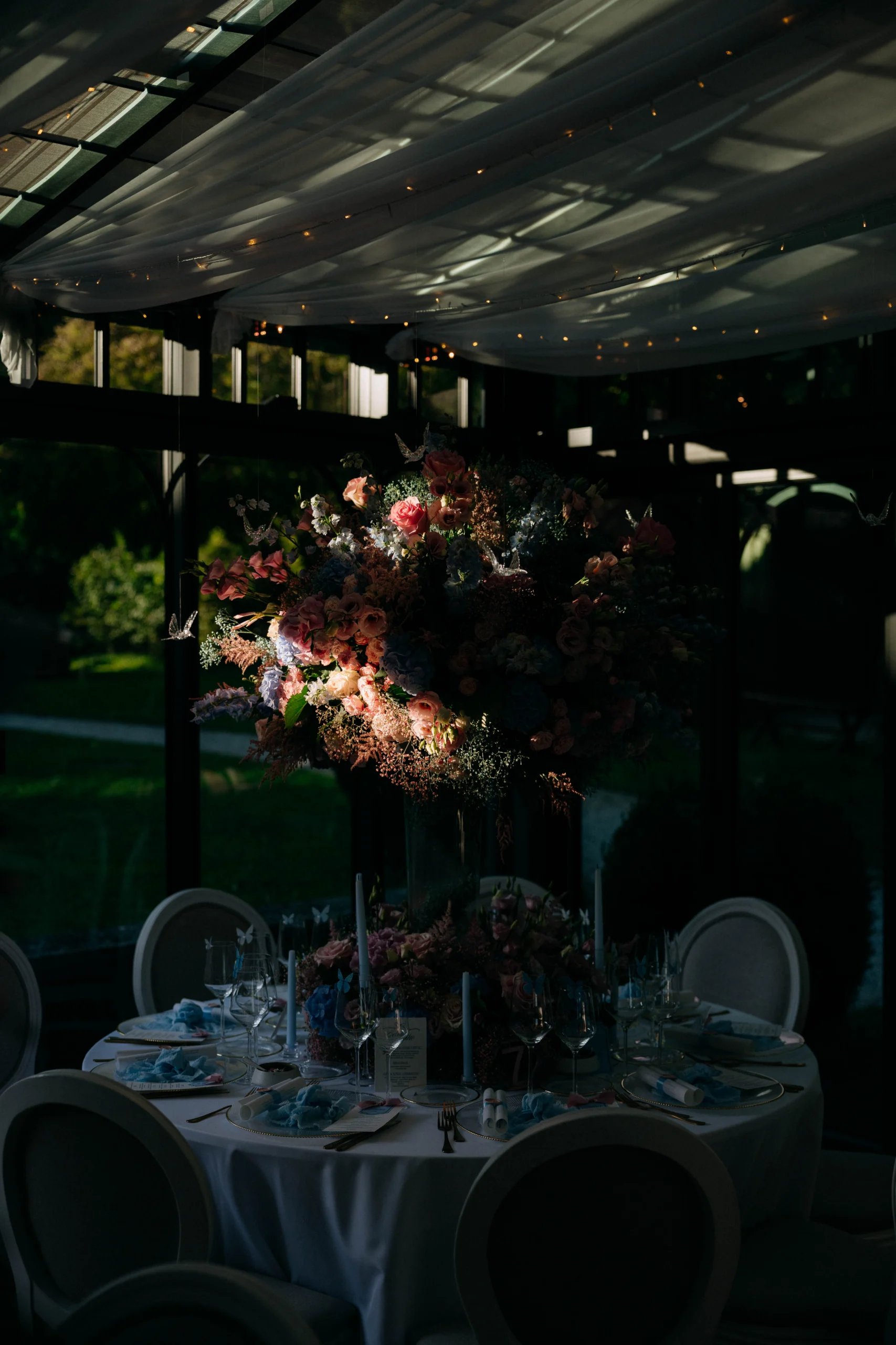 Reception table with lush florals under a draped ceiling, wedding in Munich at La Villa
