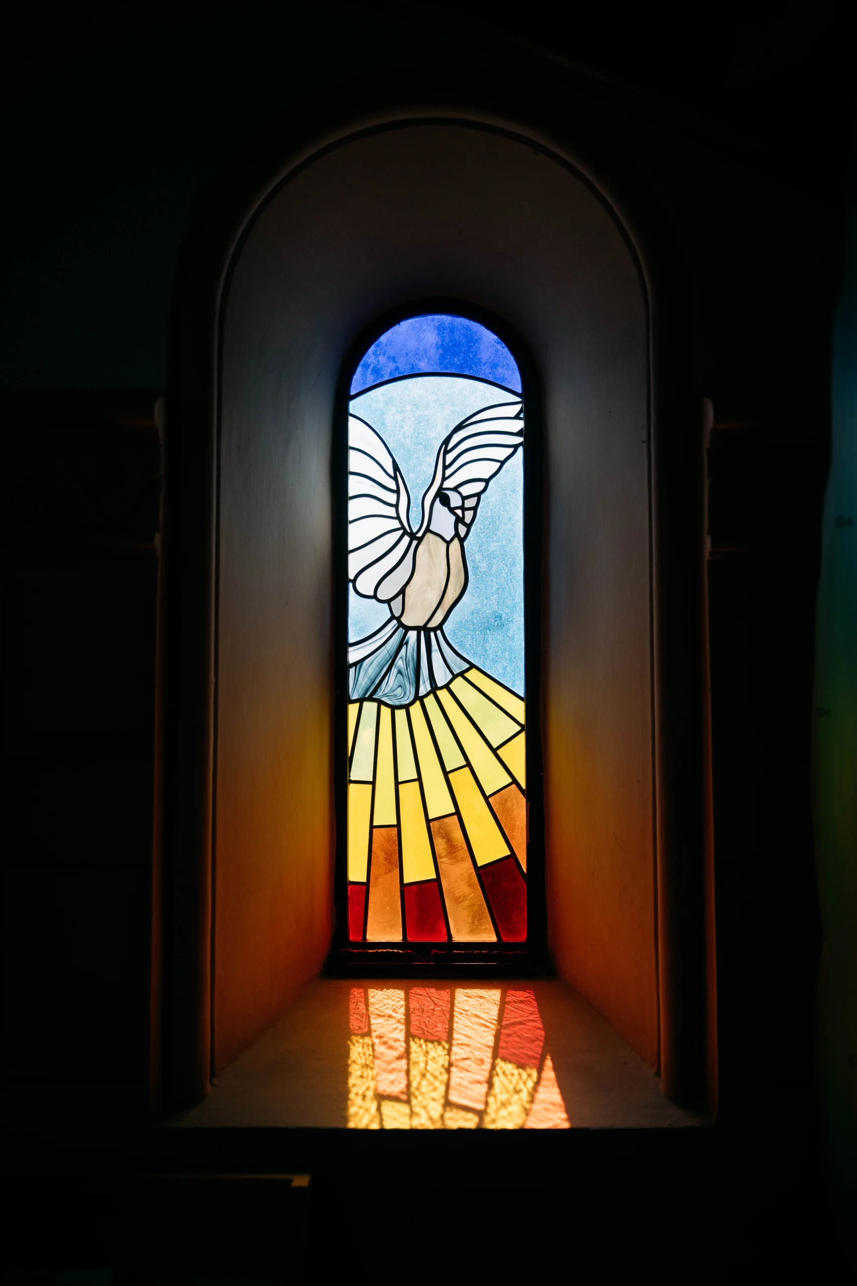 Stained glass church window with a dove and light reflection, Munich wedding at La Villa