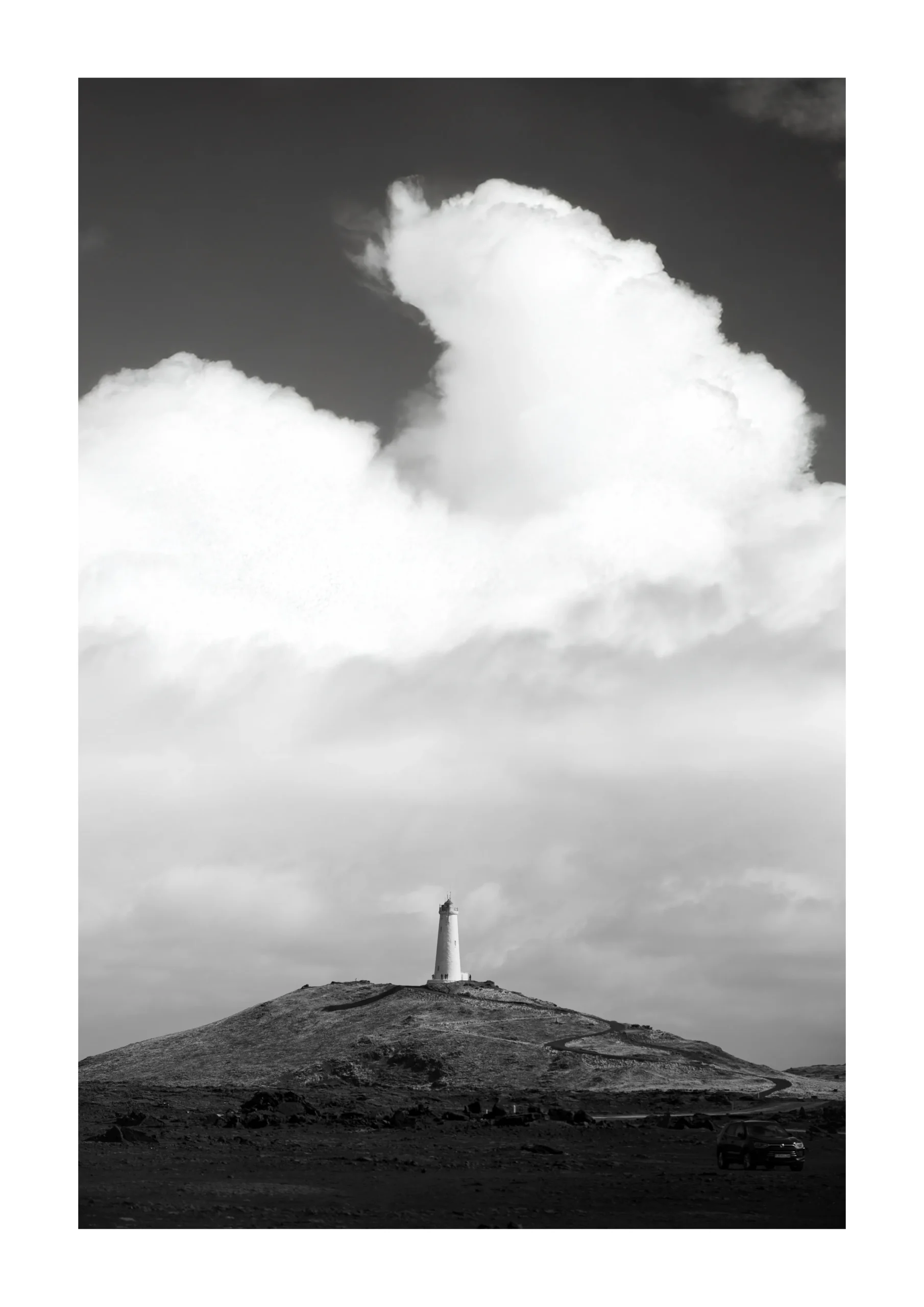 Black and white Fine Art Print of a lighthouse under dramatic clouds