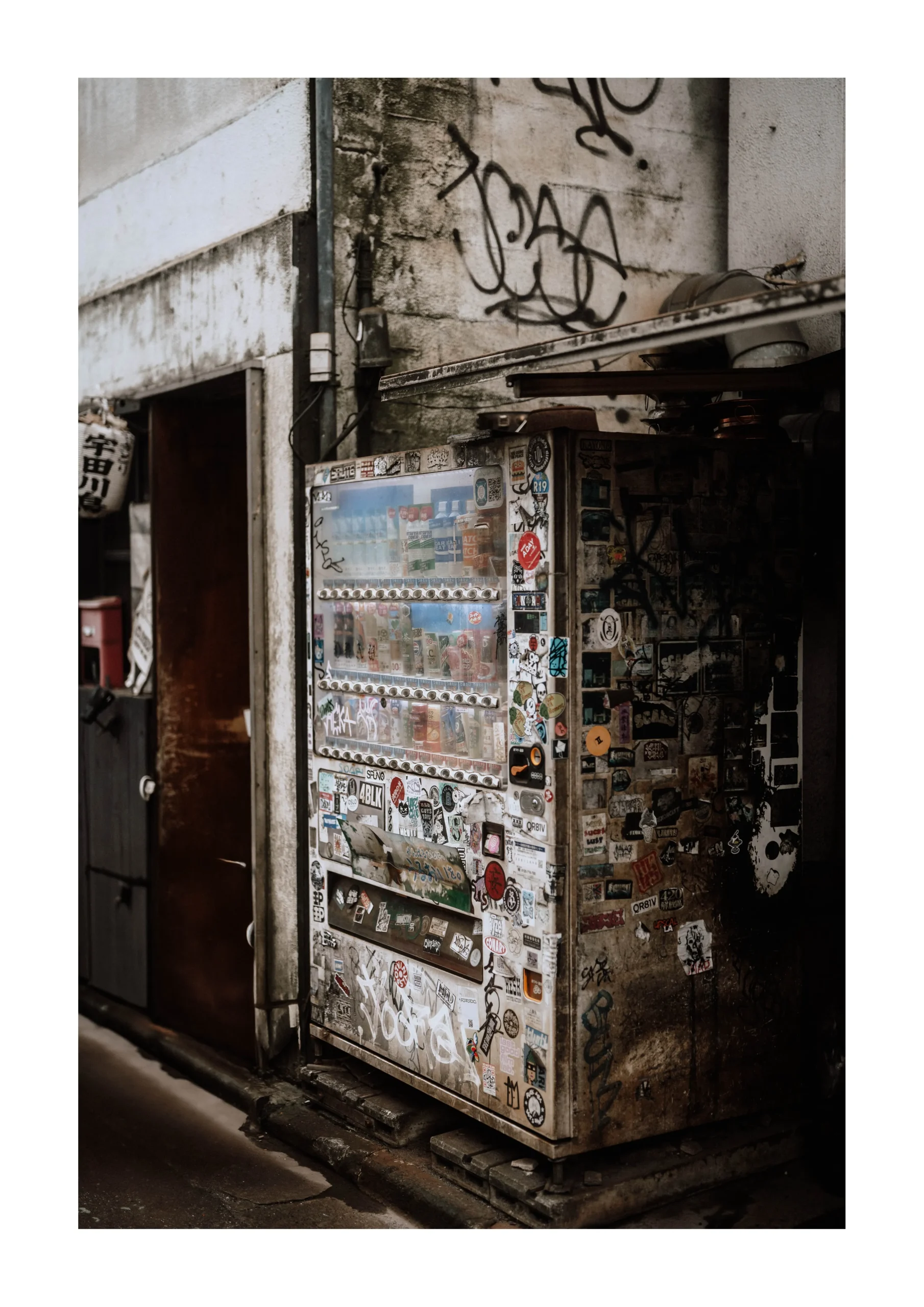 Tokyo fine art print of a sticker covered street corner at night