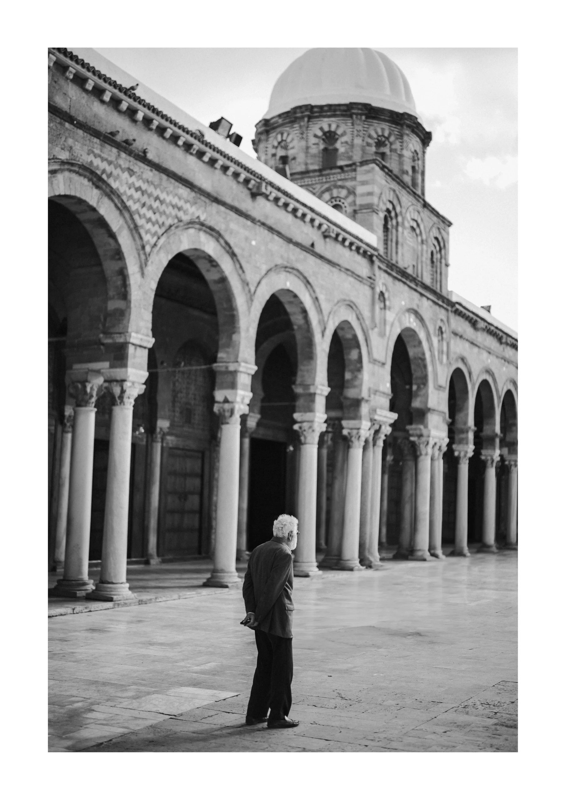 Tunis fine art print of an elderly man walking past historic arches