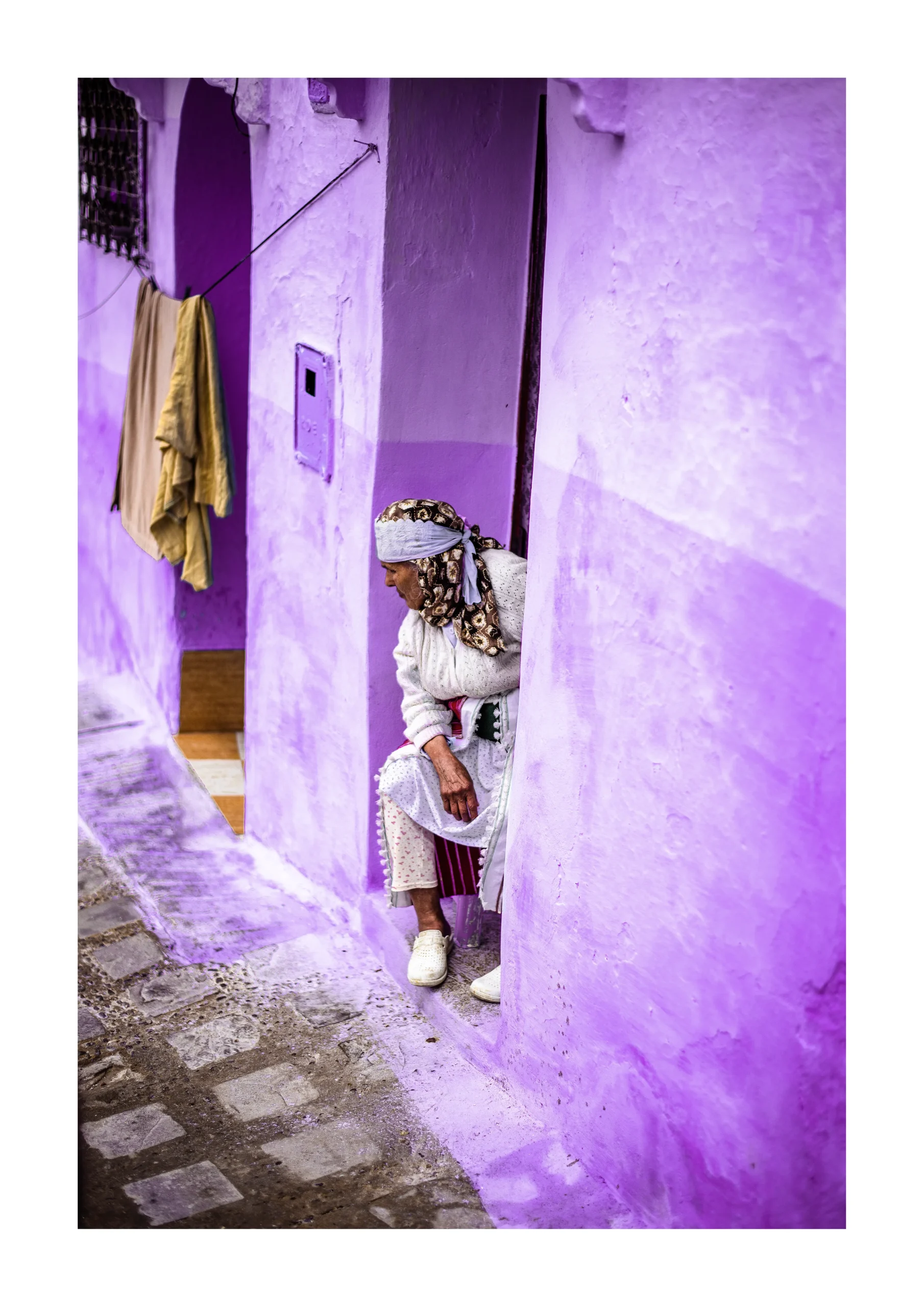 Chefchaouen fine art print of a woman sitting in a purple Moroccan alley