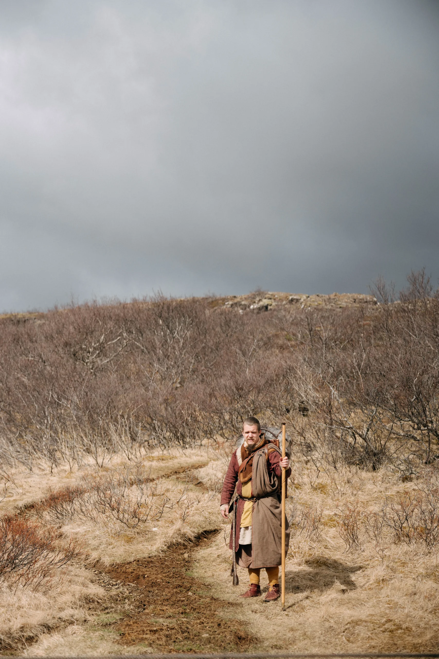 Man in Viking costume with walking staff on trail through Iceland