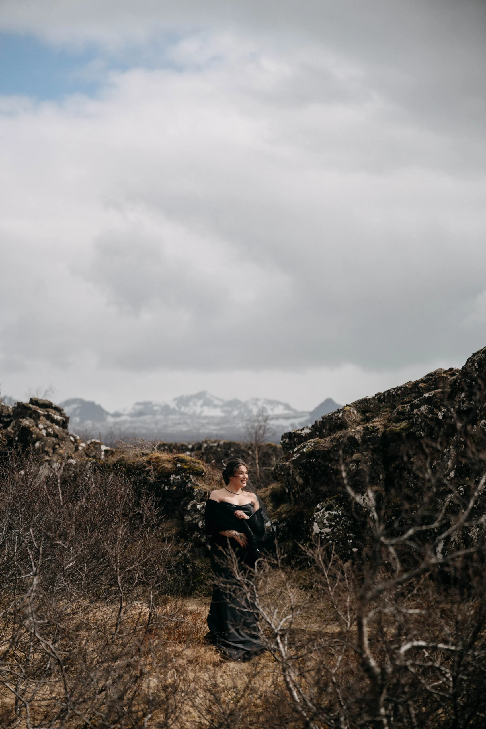 Bride in black dress in Icelandic lava landscape with mountains