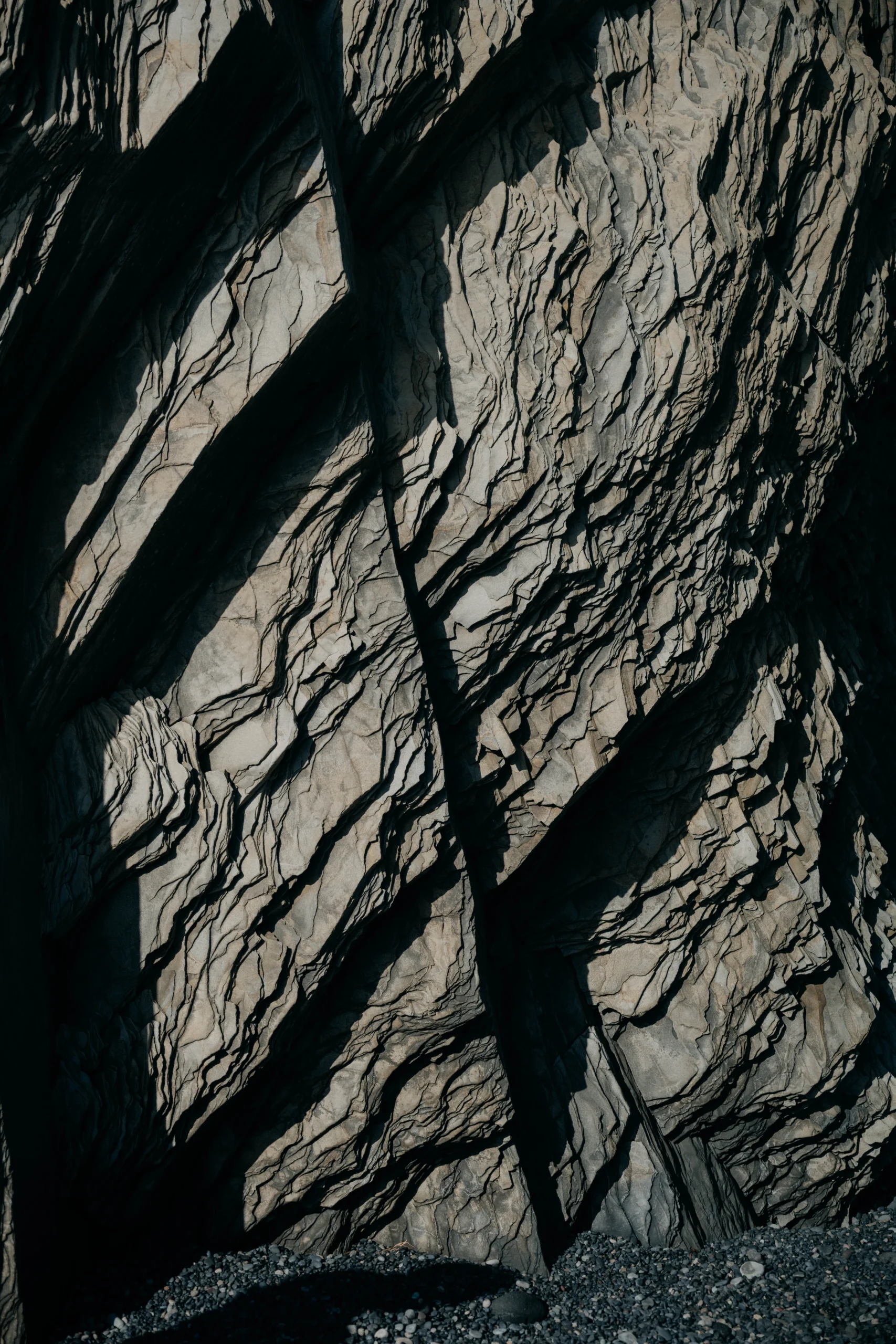 Close-up of layered rock texture with dramatic shadow, black and white