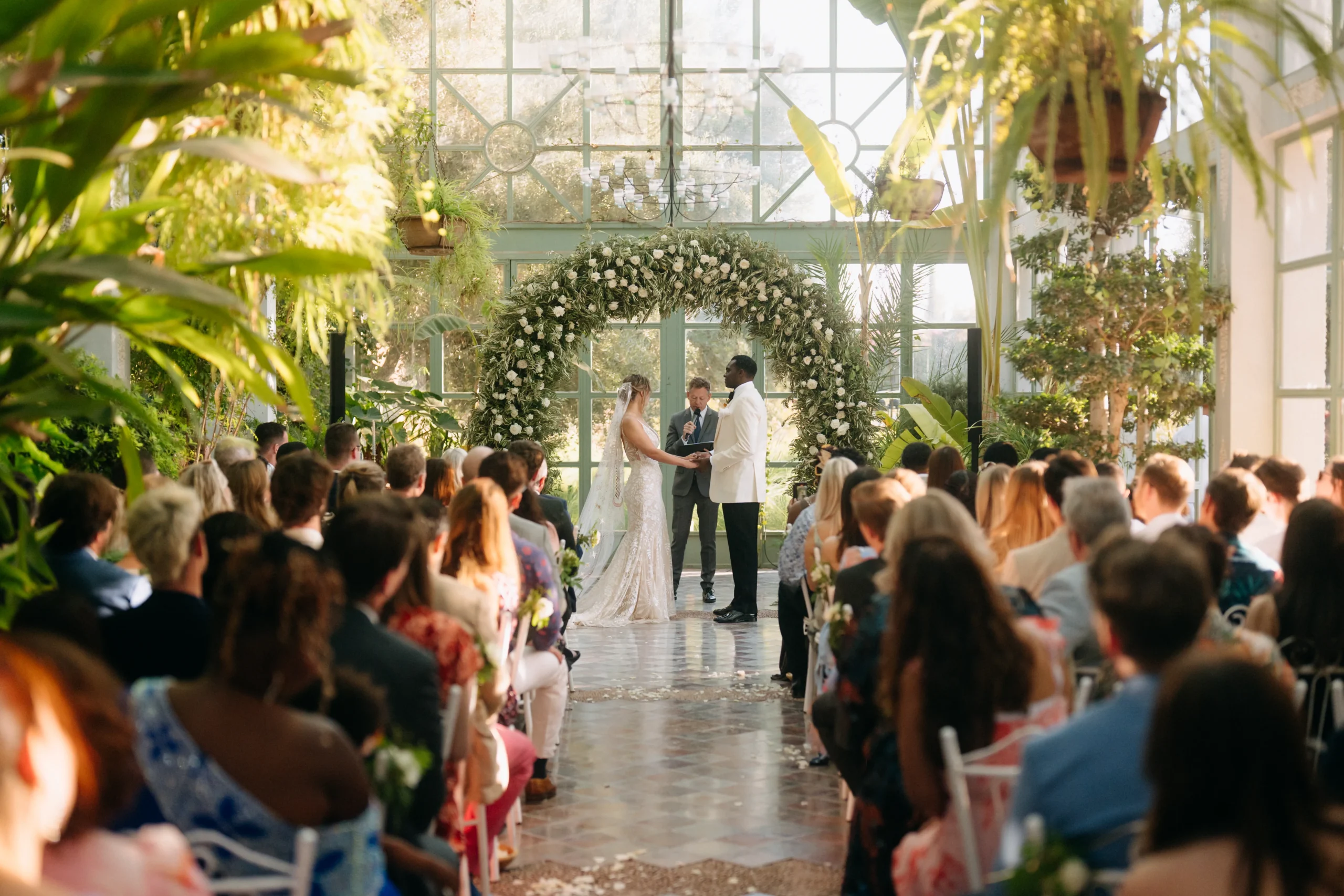 Wedding ceremony in Marrakech greenhouse with floral arch and natural light