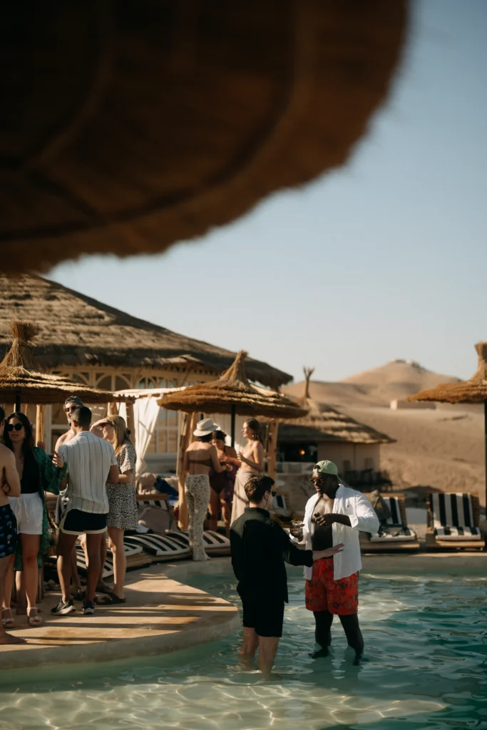 Wedding guests relaxing by the pool at Be Agafay desert camp near Marrakech after a three-day wedding